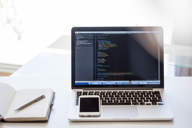 Kerala-based digital marketer workspace with laptop, code, and notebook on white desk"